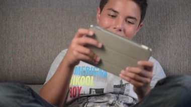 Dijital tablet oynayan genç çocuk