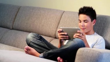 Dijital tablet oynayan genç çocuk