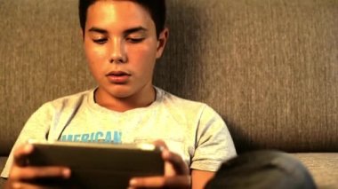 Dijital tablet oynayan genç çocuk