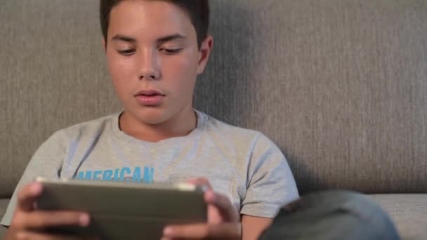 Έφηβος-νέος αγόρι που παίζει από ψηφιακή δισκίο — Αρχείο Βίντεο