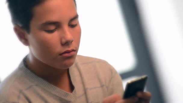 Genç genç müzik yaptığı telefon dinlemek bir kanepe üzerinde yalan — Stok video