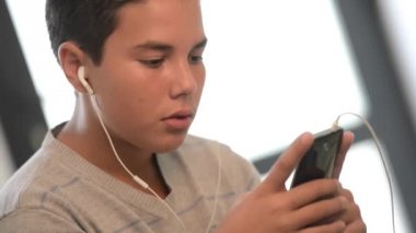 Genç genç müzik yaptığı telefon dinlemek bir kanepe üzerinde yalan