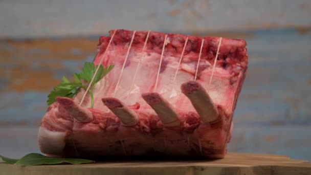 Pork ribs on turntable, Pork ribs with raw bone, Entrecote, Fresh and raw meats. Organic food, Meat with spices: pepper, salt, bay leaf, rosemary and its vegetables — Stock Video