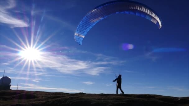 Siklóernyő repül át a hegyeken a nyári nap előtt a hegy — Stock videók