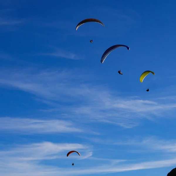 Parapente survolant les montagnes en journée d'été en face de la montagne — Photo