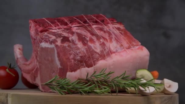 Schweinerippchen auf Plattenteller, Schweinerippchen mit rohem Knochen, Entrecote, Frisches und rohes Fleisch. Biologische Lebensmittel, Fleisch mit Gewürzen: Pfeffer, Salz, Lorbeerblatt, Rosmarin und sein Gemüse — Stockvideo