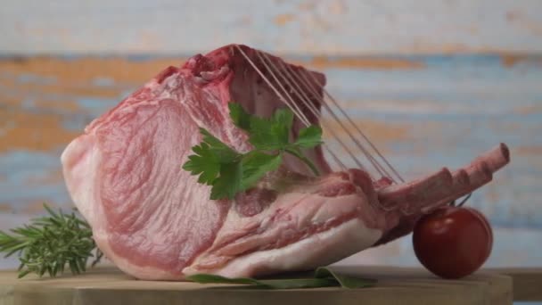 Fläskrevben på skivtallrik, Fläskrevben med rått ben, Entrecote, Färskt och rått kött. Ekologisk mat, kött med kryddor: peppar, salt, lagerblad, rosmarin och dess grönsaker — Stockvideo