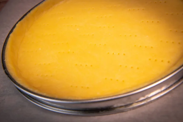 Metal fork makes holes in a raw pastry case in a metal baking tin — Stock Photo, Image