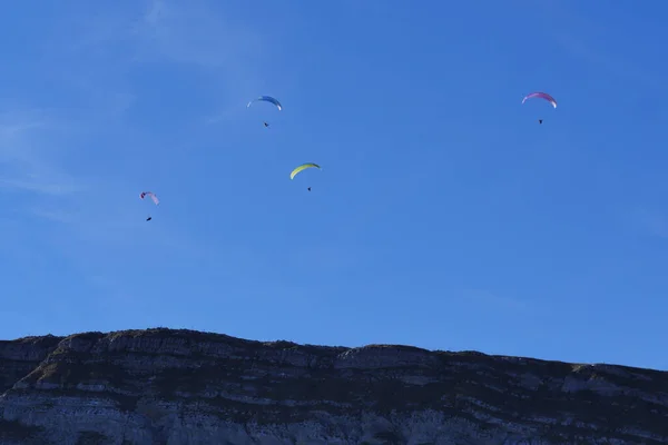 Parapente survolant les montagnes en journée d'été en face de la montagne — Photo