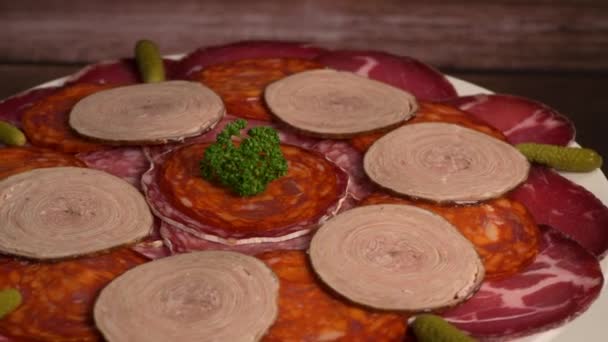 Bandeja de comida con delicioso salami, trozos de jamón en rodajas, salchichas, embutidos, encurtidos — Vídeos de Stock
