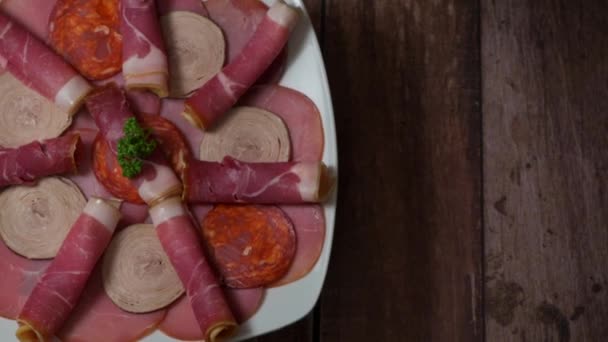 Bandeja de comida con delicioso salami, trozos de jamón en rodajas, salchichas, embutidos, encurtidos — Vídeos de Stock