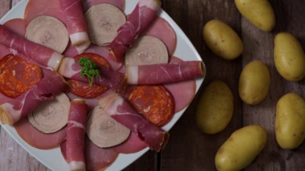 Bandeja de comida con delicioso salami, trozos de jamón en rodajas, salchichas, embutidos, encurtidos — Vídeos de Stock
