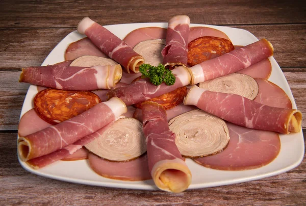 Taca z pysznym salami, kawałki szynki w plasterkach, kiełbasa, wędliny, ogórki — Zdjęcie stockowe