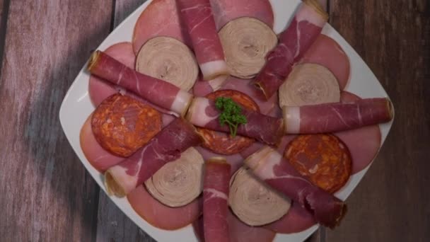 Bandeja de comida con delicioso salami, trozos de jamón en rodajas, salchichas, embutidos, encurtidos — Vídeos de Stock