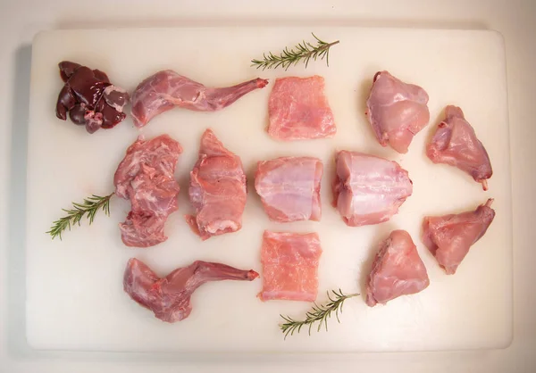 Raw rabbit cut out on a white cutting board. Top view, flat lay, close up. — Zdjęcie stockowe