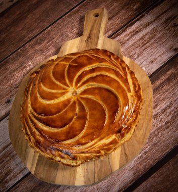 Galette des rois on wooden table, Traditional Epiphany cake in France