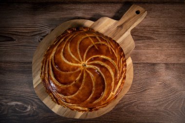 Galette des rois on wooden table, Traditional Epiphany cake in France