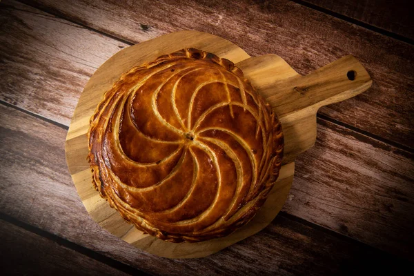 Galette des rois on wooden table, Traditional Epiphany cake in France