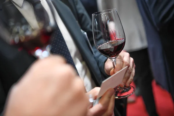 Pessoas degustando vinho tinto em exposição profissional — Fotografia de Stock