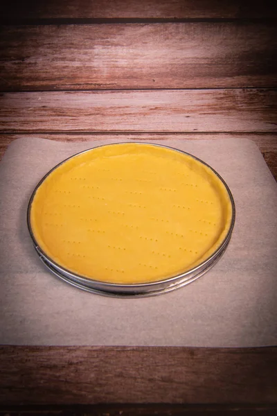 Metal fork makes holes in a raw pastry case in a metal baking tin — Stock Photo, Image