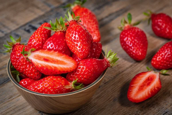 Frische Erdbeeren in einer Schüssel auf Holztisch mit niedriger Schlüsselszene — Stockfoto