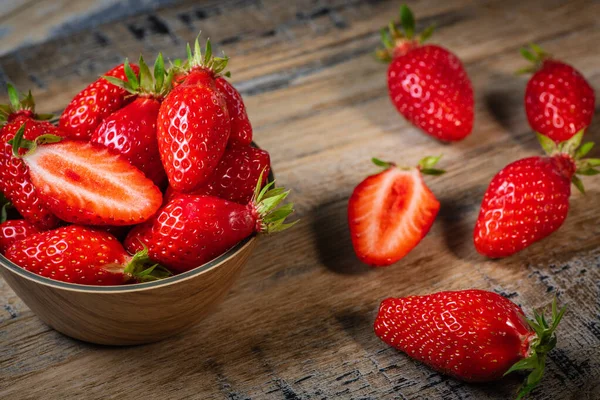 Frische Erdbeeren in einer Schüssel auf Holztisch mit niedriger Schlüsselszene — Stockfoto