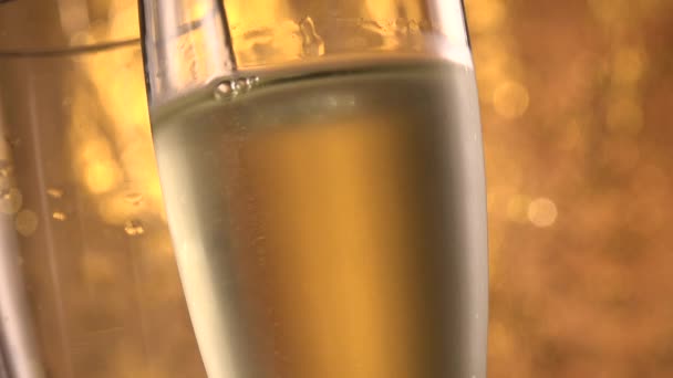 香槟酒杯盖在节日酒壶的背景上闪烁，在转盘上旋转，酒杯上有闪闪发光的葡萄酒，庆祝会，派对 — 图库视频影像