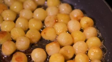 Frying hazelnut potatoes in a pan