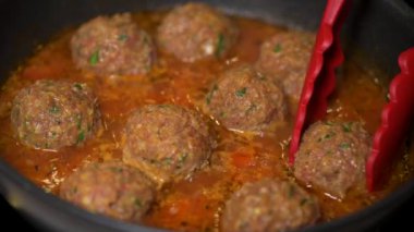 Tavada domates soslu köfte pişirmek. 