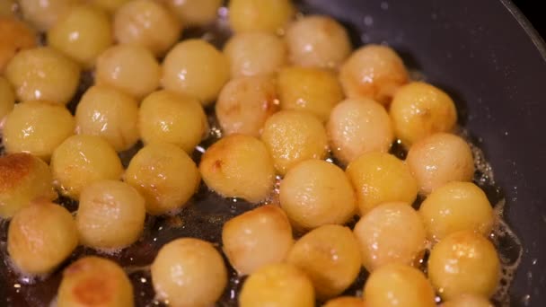 Frying hazelnut potatoes in a pan — стоковое видео