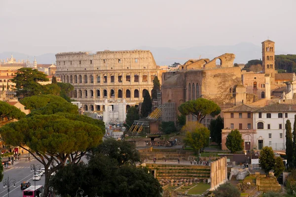 Róma, 03.20.2021, Colosseum napnyugtakor felhőkkel és ciprusokkal, Róma, Olaszország — Stock Fotó