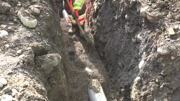 Loupáním štěrku na staveništi na ochranu odvodňovacího potrubí — Stock video