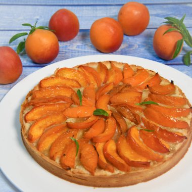 Kayısılı tart, kumlu macun, badem kremi, verbena süslemesi. Yüksek kalite fotoğraf