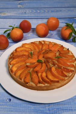 Kayısılı tart, kumlu macun, badem kremi, verbena süslemesi. Yüksek kalite fotoğraf