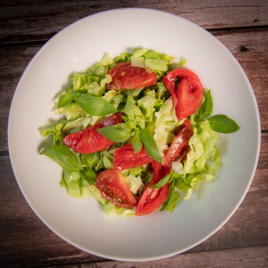 Green vegan salad, tomato and basilic from green leaves mix and vegetables, High quality photo