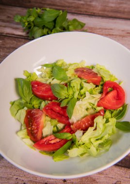 Green vegan salad, tomato and basilic from green leaves mix and vegetables, High quality photo