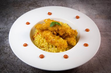 Recipe for chicken tenders with corn flakes and Italian Piombo pasta risotto and peppers. High quality photo