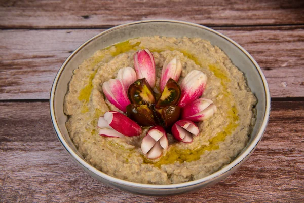 Eggplant caviar with homemade and radish and tomatoes on wooden background. High quality photo