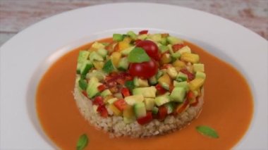 Vegan salad recipe based on bulgur with small vegetables, avocado, tomato, cucumber, pepper, nectarine fruit, tomato basil sauce and olive oil and lemon