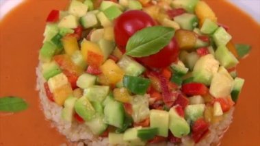 Vegan salad recipe based on bulgur with small vegetables, avocado, tomato, cucumber, pepper, nectarine fruit, tomato basil sauce and olive oil and lemon