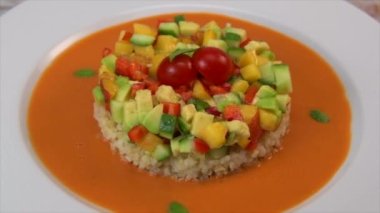 Vegan salad recipe based on bulgur with small vegetables, avocado, tomato, cucumber, pepper, nectarine fruit, tomato basil sauce and olive oil and lemon