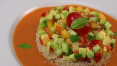 Vegan salad recipe based on bulgur with small vegetables, avocado, tomato, cucumber, pepper, nectarine fruit, tomato basil sauce and olive oil and lemon