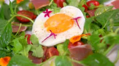 Mafya, roket, vişneli domates, pişirilmiş jambon ve balzamik soslu salata üzerine kızarmış yumurta. Yüksek kalite fotoğraf