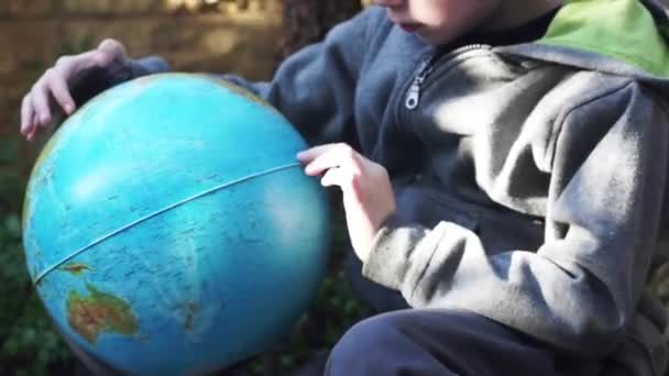 Kind spelen met de globus — Stockvideo