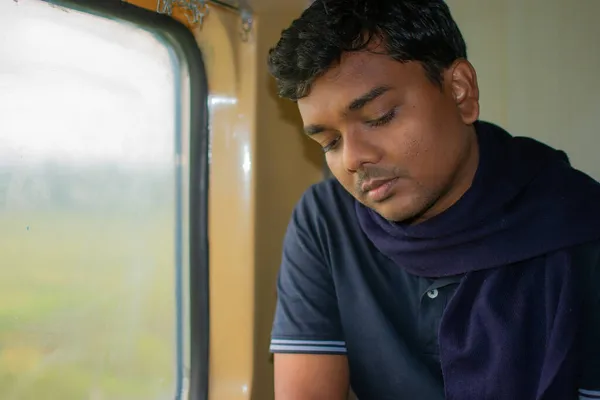 列車の窓の外を見ている若いインド人男性 インドの高速急行列車で旅行中の乗客の肖像 — ストック写真