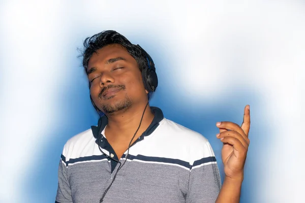 Nuori Komea Intialainen Mies Kuulokkeissa Kuuntelemassa Musiikkia Eristetty Valkoinen Tausta — kuvapankkivalokuva