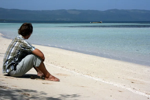 Mladý muž na břehu moře, při pohledu na moře Royalty Free Stock Fotografie