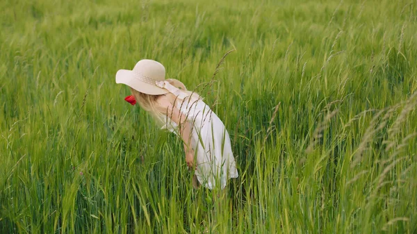 Çavdar alanında sıcak ve bulutlu yaz gününde yürüyüş uzun saçlı kız.