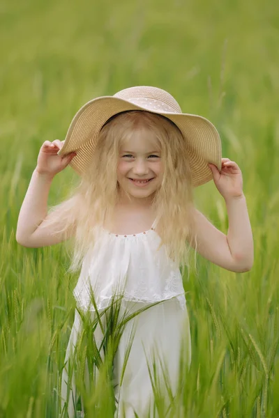 Çavdar alanında sıcak ve bulutlu yaz gününde yürüyüş uzun saçlı kız.