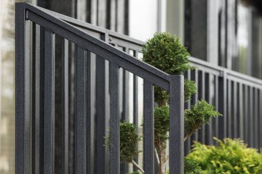 Modern bir apartmanın peyzajında siyah metal parmaklıklar..